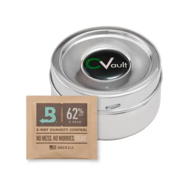 A CVault Twist Small Humidity Control Airtight Metal Smell Proof Container by CVault sits beside a brown Boveda 62% 8g 2-way humidity control packet.